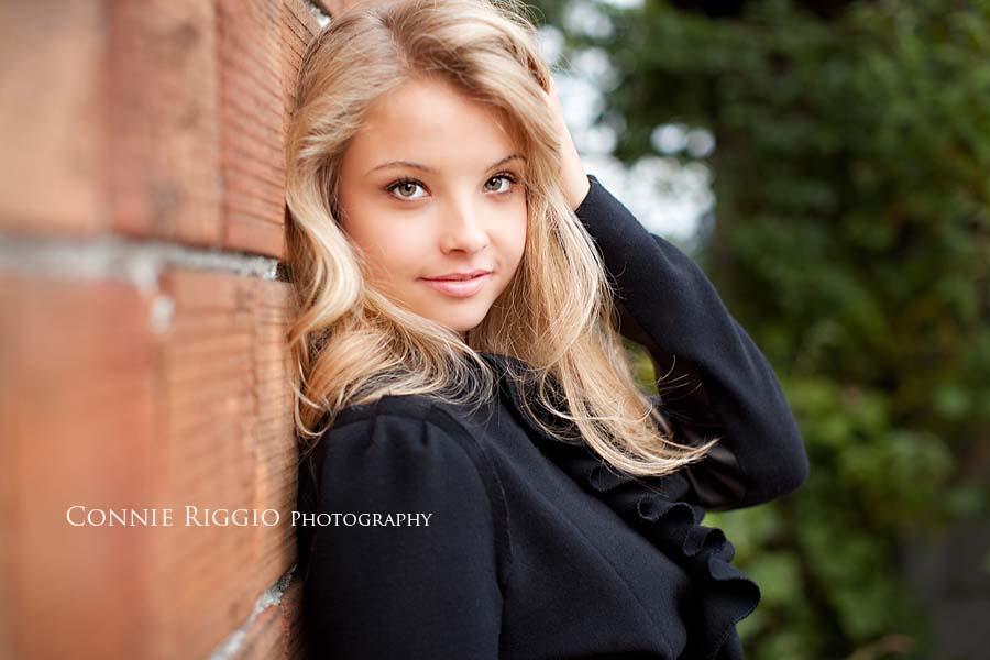 Black Coat against brick Tacoma Best Senior Photographer